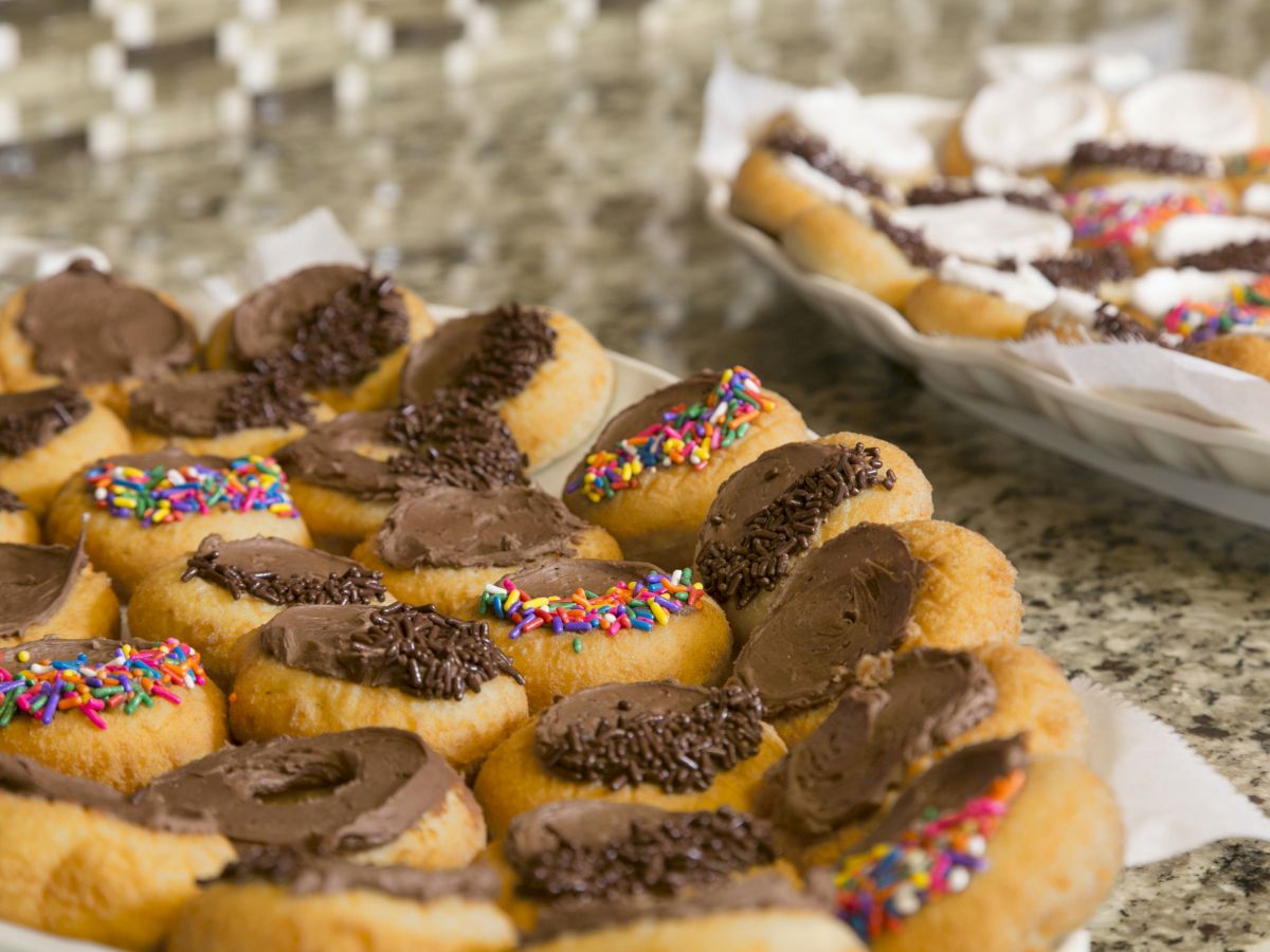 The image shows two plates of pastries topped with chocolate and colorful sprinkles, set on a granite countertop.