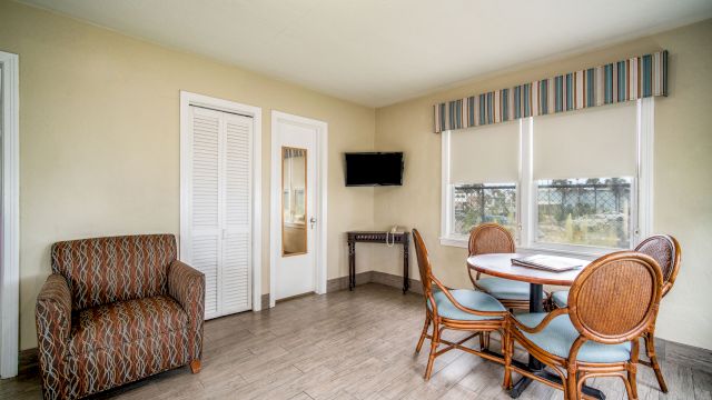 A wide view of a room with a sofa, dining table, TV, and window