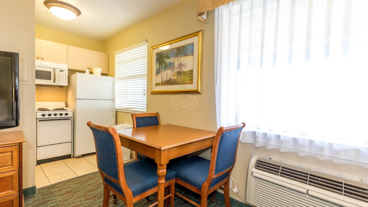 A kitchenette with a dining area, appliances, and a window with a view.