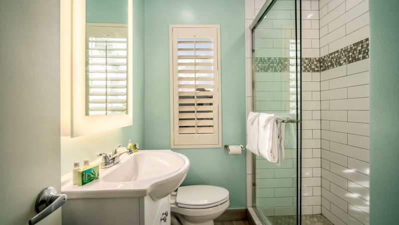 A clean bathroom with a sink, toilet, and shower.