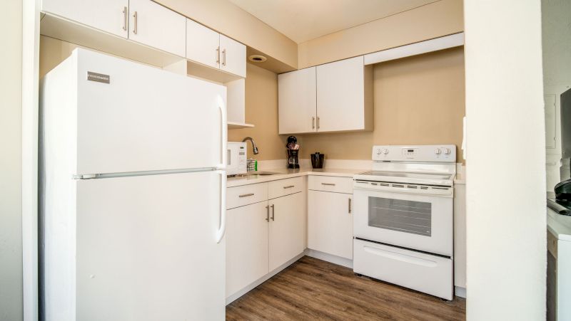A kitchen with white appliances and cabinets