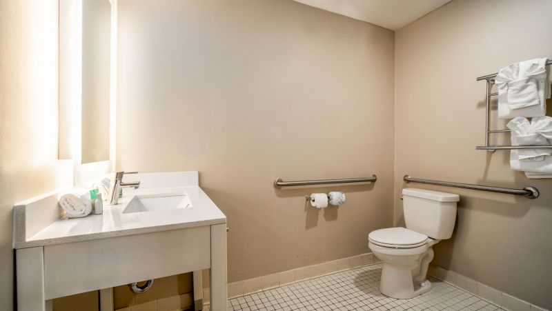 A clean bathroom with a toilet, sink, and towels.