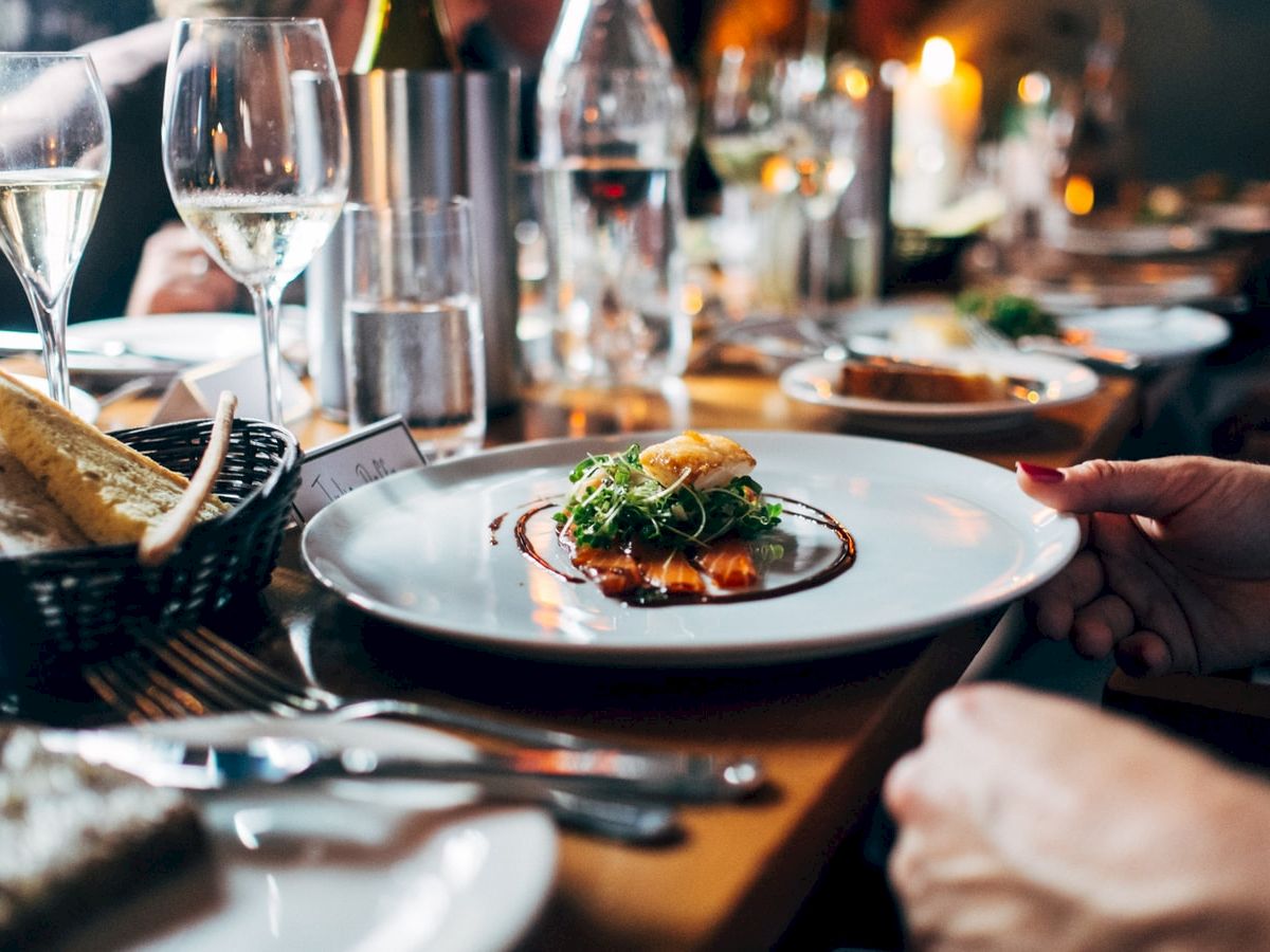 A plate of food on a table with wine glasses and bread