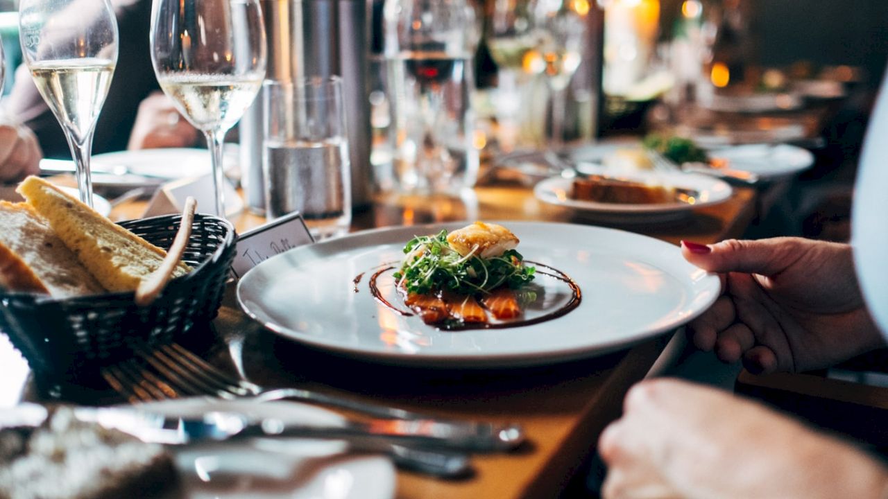 A plate of food with bread and wine glasses on a table.
